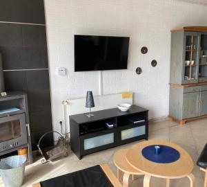 a living room with a table and a tv on a wall at Friesenkoje Tossens in Butjadingen