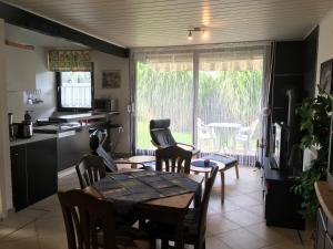 a kitchen and dining room with a table and chairs at Friesenkoje Tossens in Butjadingen +9 photos