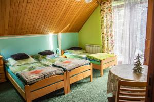 two twin beds in a room with a table at Kwatery prywatne u Danusi in Wierchomla Wielka +29 photos