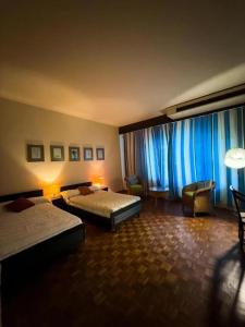 Un dormitorio con dos camas y una ventana con cortinas azules. en eskimo bungalow by Fic 369, en Kadirana North