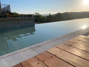 巴拉聚克Villa Balazuc的有木地板和水的游泳池