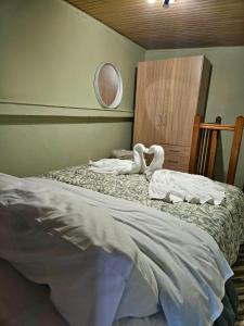 - une chambre avec deux cygnes assises sur un lit dans l'établissement Elysium House, à Salamine