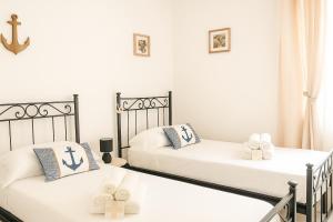 Camera con 2 letti singoli e pareti bianche. di Appartamenti Mirante a Campomarino