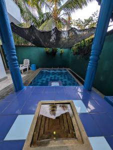 Ein Pool mit einer Palme im Hintergrund in der Unterkunft Andy Home Stay, Balapitiya in Balapitiya