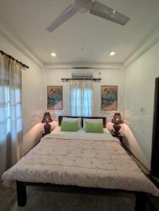 ein Schlafzimmer mit einem großen Bett mit zwei grünen Kissen in der Unterkunft Andy Home Stay, Balapitiya in Balapitiya