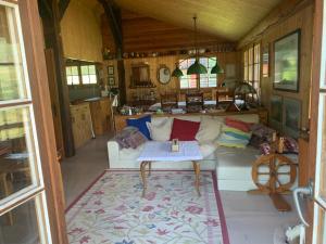 una sala de estar con un sofá y una mesa en Chalet le Moulin - calme, nature, cheminée, vue, en Liddes
