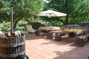 a patio with an umbrella and a table and chairs at Case Zuccaro in Trecastagni