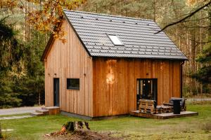 Cabaña de madera grande con techo negro en Modřínka 89, en Chlum u Třeboně