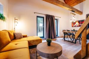 Una sala de estar con un sofá amarillo y una mesa. en Modřínka 89, en Chlum u Třeboně