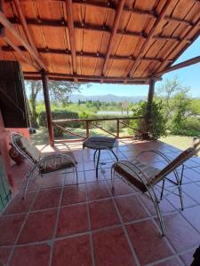 een patio met stoelen, een tafel en een dak bij Suspiro de Montaña in Casa Grande