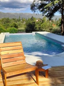 een houten bank op een terras naast een zwembad bij Suspiro de Montaña in Casa Grande