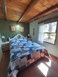 een slaapkamer met een bed met een dekbed erop bij Suspiro de Montaña in Casa Grande