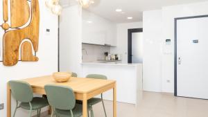 a kitchen and dining room with a wooden table and chairs at SUNSET SAILORS vibe apartment in Benidorm