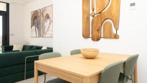a dining room with a table and a green couch at SUNSET SAILORS vibe apartment in Benidorm +36 photos