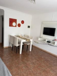 a dining room with a table and chairs and a tv at Fenix 2 in Colón