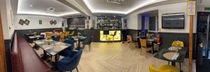 a restaurant with tables and chairs and a bar at The Gatwick White House Hotel in Horley