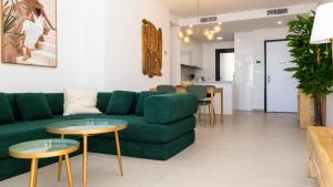 a living room with a green couch and tables at SUNSET SAILORS vibe apartment in Benidorm