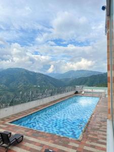 une piscine avec des montagnes en arrière-plan dans l'établissement Apartamento acogedor en Bucaramanga con piscina, à Bucaramanga