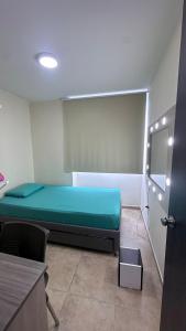 une chambre avec un lit vert dans une chambre avec une porte dans l'établissement Apartamento acogedor en Bucaramanga con piscina, à Bucaramanga