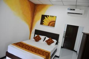 Un dormitorio con una cama y un cuadro en la pared. en Jonathan`s way, en Negombo