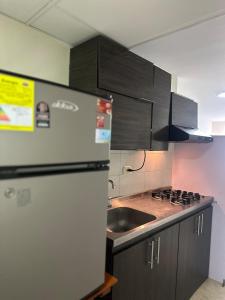 une cuisine avec un réfrigérateur blanc et un évier dans l'établissement Apartamento acogedor en Bucaramanga con piscina, à Bucaramanga