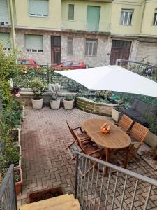 une table et des chaises avec un parasol sur une terrasse dans l'établissement Casa Grace Relax nel cuore del Monferrato, à Casale Monferrato