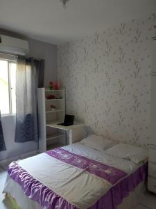 Desfrute de Belém em um apto incrível في بيليم: غرفة نوم مع سرير وجهاز كمبيوتر محمول على مكتب