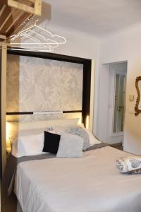 une chambre avec un grand lit avec des draps blancs dans l'établissement Casa Grace Relax nel cuore del Monferrato, à Casale Monferrato