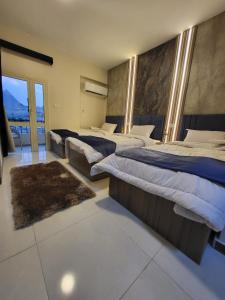 een grote slaapkamer met drie bedden en een groot raam bij The Tree Pyramids Inn in Caïro