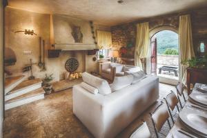 a living room with a white couch and a fireplace at Medieval Tower In Sibillini Mountains Park in Vetice