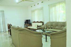 ein Wohnzimmer mit Sofa und Tisch in der Unterkunft Villa Heritance in Badulla