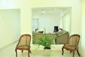 Una sala de estar con dos sillas y un sofá. en Villa Heritance, en Badulla