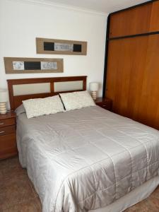 a bedroom with a large bed with a wooden headboard at Fenix 2 in Colón
