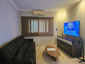 un salon avec un canapé et une télévision à écran plat dans l'établissement Chácara Urbana, à Juazeiro