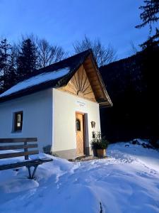 uma pequena construção com uma porta de madeira na neve em Ferien am Sonnberg em Unken