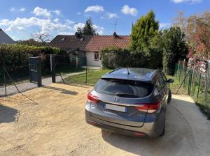 une voiture garée dans une allée devant une maison dans l'établissement Le Forterre - 2 chambres - Parking - Jardin, à Toucy