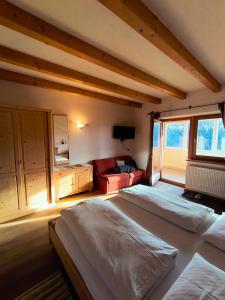 a large bedroom with two beds and a couch at Pension Ferienwohnungen Marchnerhof in Terento