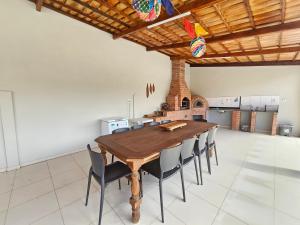 een grote eetkamer met een houten tafel en stoelen bij Chácara Urbana in Juazeiro