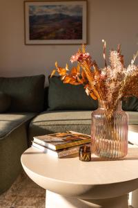 耶什赫维采Apartmány Vysoká v srdci Českého Švýcarska的花瓶,桌子上放着鲜花,还有书