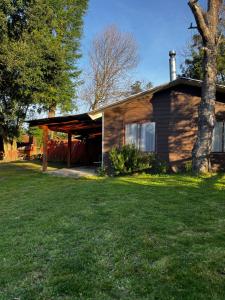 Una casa con un gran patio al frente. en Cabañas Pucontours, en Pucón