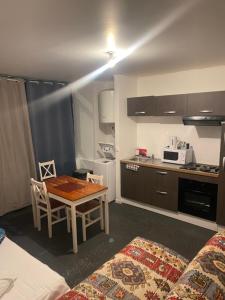 a small room with a table and a kitchen at Hotel Morez in Morez