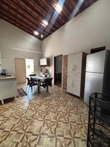 a kitchen and dining room with a table and refrigerator at Recanto Lemes in Olímpia