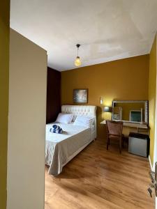 Un dormitorio con una cama, un escritorio y un espejo. en Woro Ladia, en Conakry