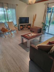 un salon avec une table basse et une télévision dans l'établissement Hermosa Casa en El Ensueño Santa Ana Colonia, à Santa Ana