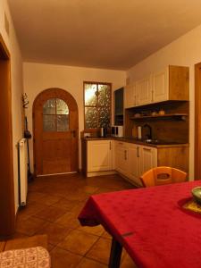 a kitchen with a table and a door in a room at Pension Ferienwohnungen Marchnerhof in Terento +30 photos