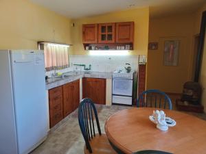 een keuken met een houten tafel en een witte koelkast bij Rancho Laramie in Huerta Grande