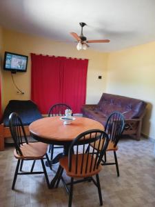 een woonkamer met een tafel, stoelen en een bank bij Rancho Laramie in Huerta Grande +12 foto's