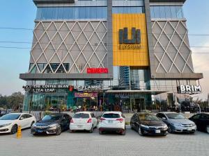 a group of cars parked in a parking lot in front of a building at Bella Hotel Apartments- Executive Stay Opposite Centaurus Mall Islamabad in Islamabad