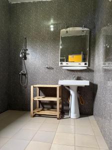 un baño con lavabo y espejo en Woro Ladia, en Conakry