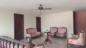 a room with chairs and a table and a ceiling fan at Suite 103 Cordoba Centro con Estacionamiento in Córdoba